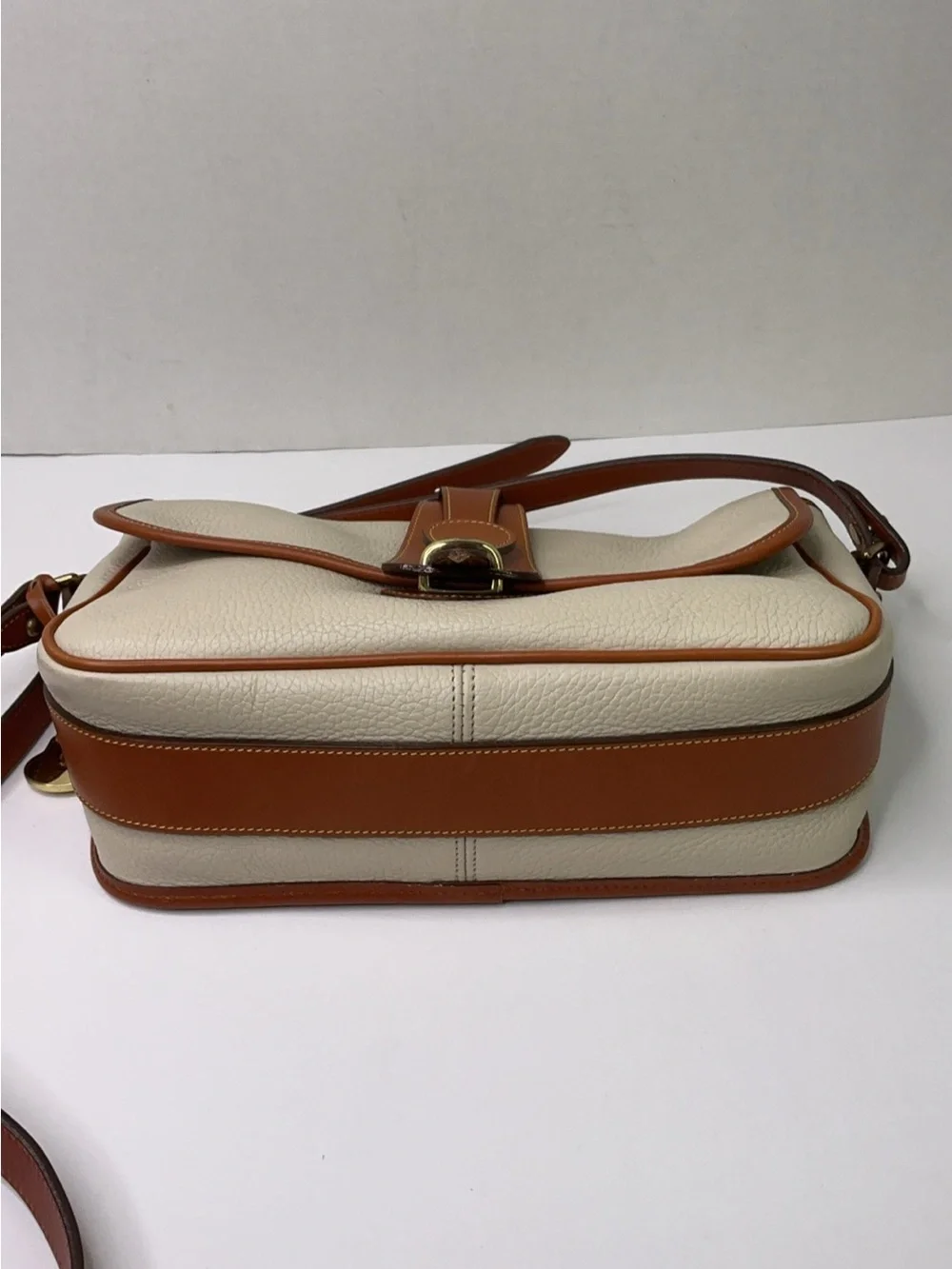 Dooney & Bourke cream and tan pebbled leather saddle bag